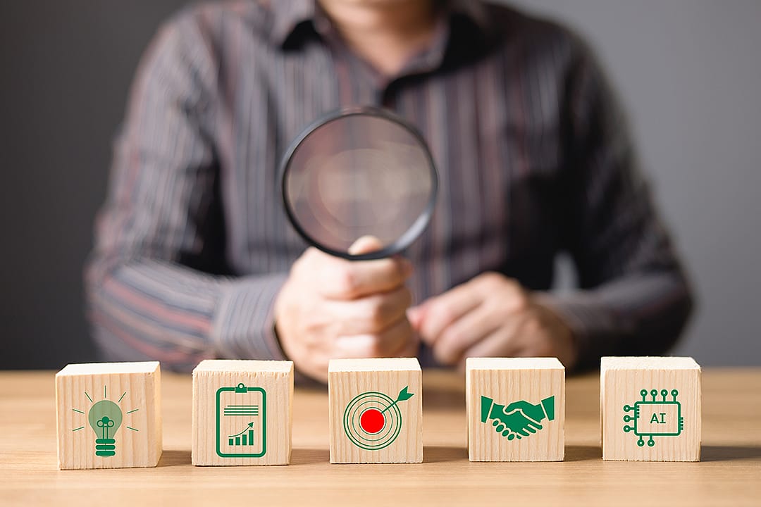 A business professional assessing enterprise strategy and AI investment tools with a magnifying glass.